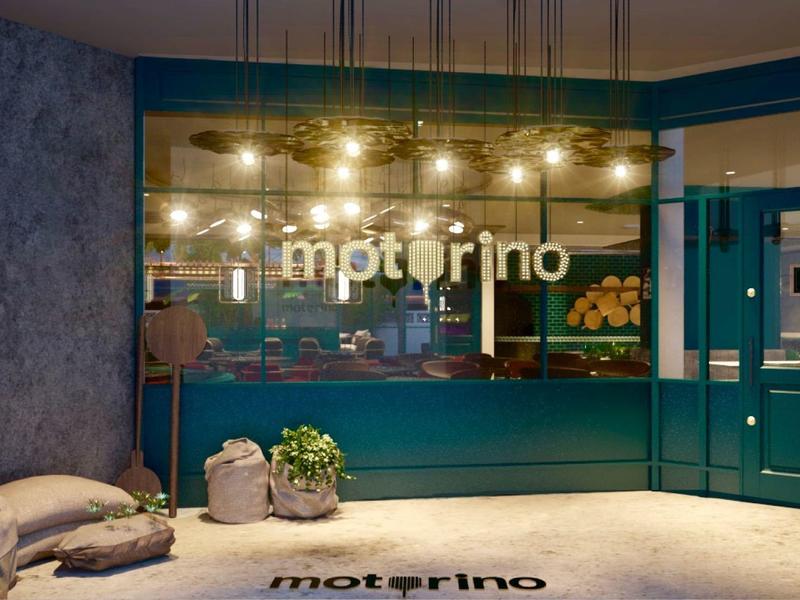 Entrée d'hôtel avec porte verte et fenêtre illuminée avec logo