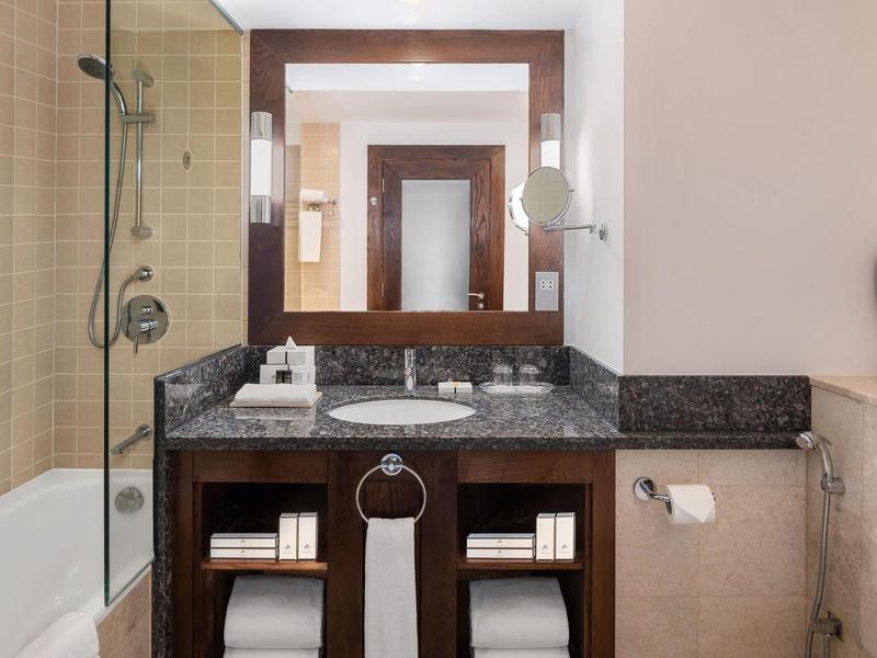 Armoire de salle de bains moderne avec lavabo intégré et grand miroir.