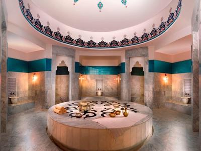Runder Marmortisch in einem großen, prunkvollen Raum mit Kuppeldecke und orientalischen Verzierungen.