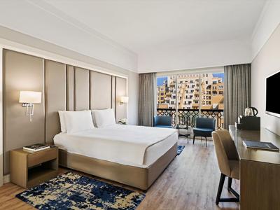 Modernes Hotelzimmer mit Queensize-Bett, Schreibtisch, Balkon und Stadtblick.