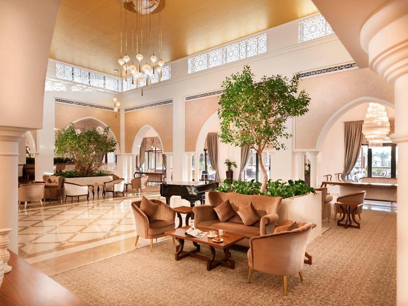 Elegante Hotel-Lounge mit bequemen Sofas, Klavier und hohen Fenstern für viel Tageslicht.