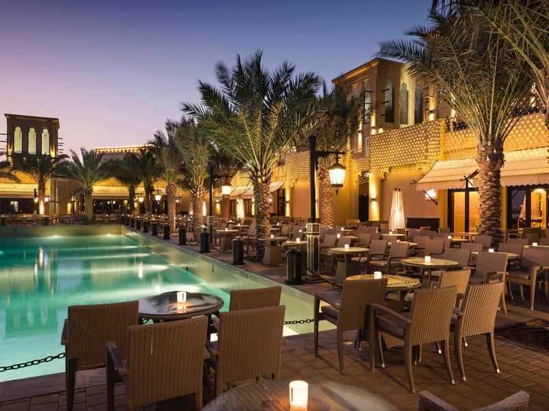 Luxuriöse Außenbereich mit Pool und Sitzgelegenheiten bei Sonnenuntergang in einem Hotel