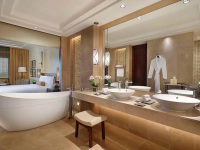 Luxuriöses Badezimmer mit großer Badewanne, Doppelwaschbecken und hellen Holzelementen.