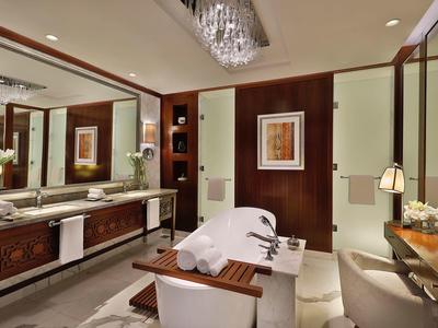 Luxuriöses Badezimmer mit freistehender Badewanne, großem Spiegel und Holzverkleidungen.