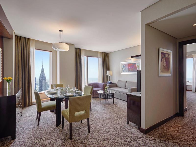 Przestronny apartament hotelowy z jadalnią, salonem i dużym oknem z widokiem.