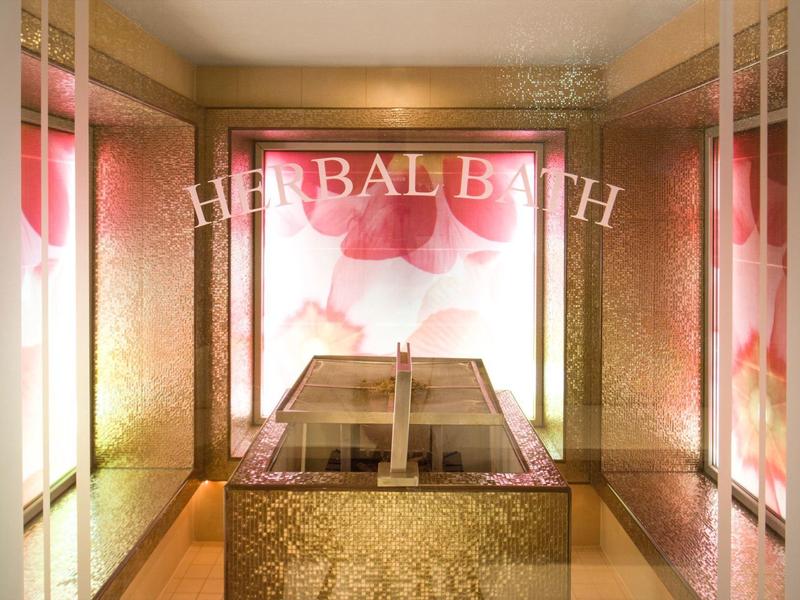 Luxuriöser Kräuterbadraum mit goldenen Wänden und illuminiertem Schriftzug