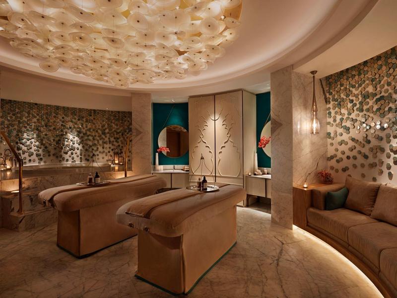 Luxuriöser Spa-Raum mit komfortablen Liegen, warmem Licht und elegantem Deckenmosaik.