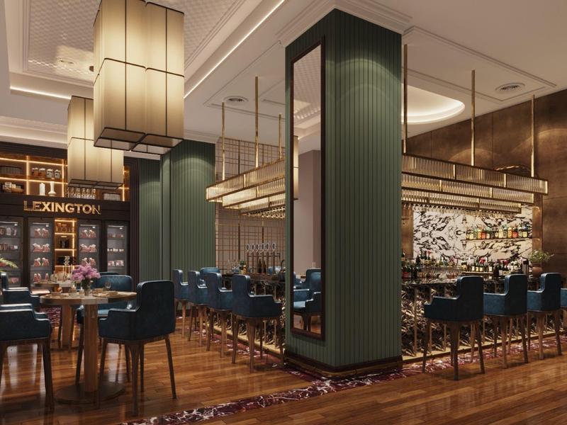 Modernes Restaurant mit Holzboden, grünen Säulen, blauen Stühlen und großen Lampenschirmen.