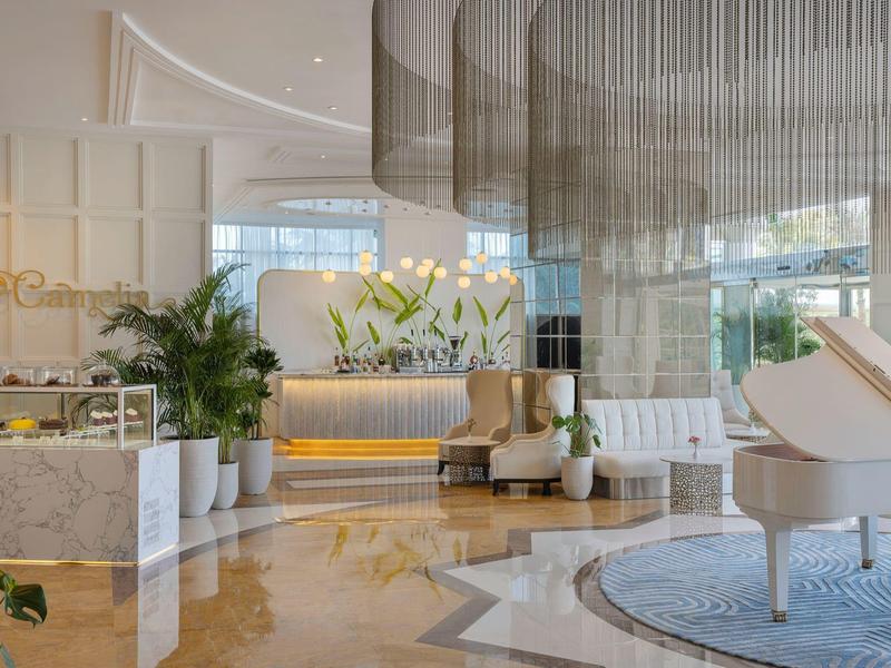 Elegante Hotellobby mit weißem Klavier, Blumenarrangements und modernem Design