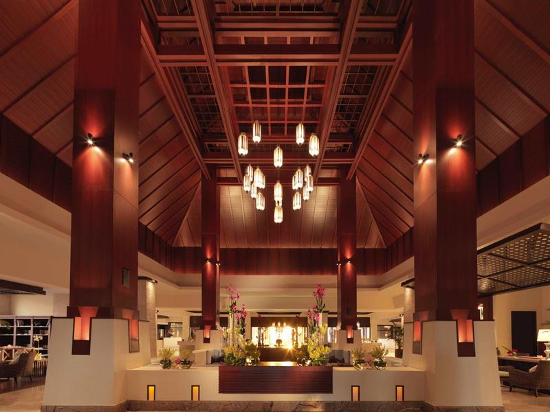 Großer, heller Innenraum mit hohen Holzbalken, Kronleuchtern und modernen Sitzbereichen.