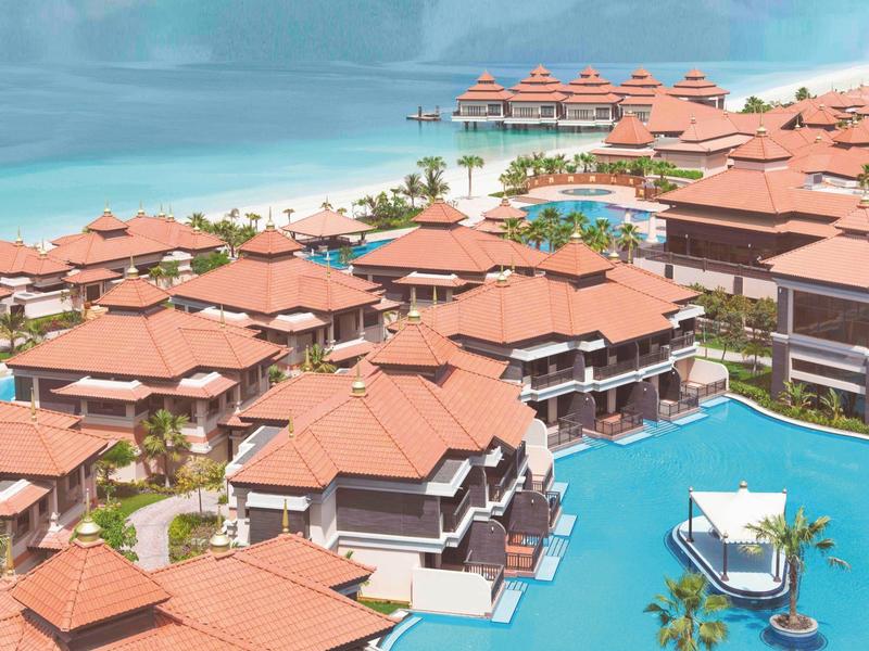 Luxuriöse Resortanlage mit roten Dächern, mehreren Pools und direktem Zugang zum Meer.