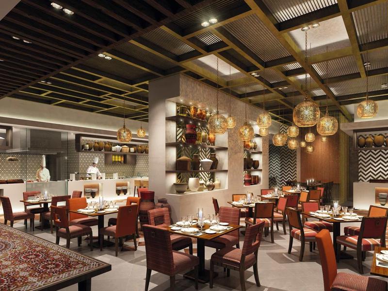 Elegantes Restaurant mit Holzstühlen, gedeckten Tischen und warmen Hängelampen.