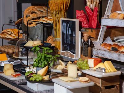 Buffet with assorted breads, cheese, and fresh vegetables at a hotel