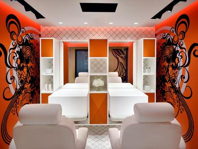 Modern spa area with massage beds and bright orange walls