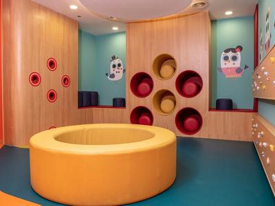 Colorful playroom with padded circular structures in a hotel.