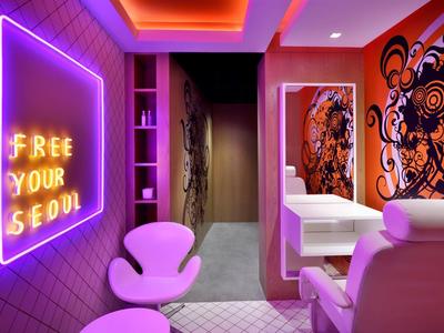 Nowoczesna przestrzeń hotelowa lub salon z różowym oświetleniem i sztuką na ścianach.