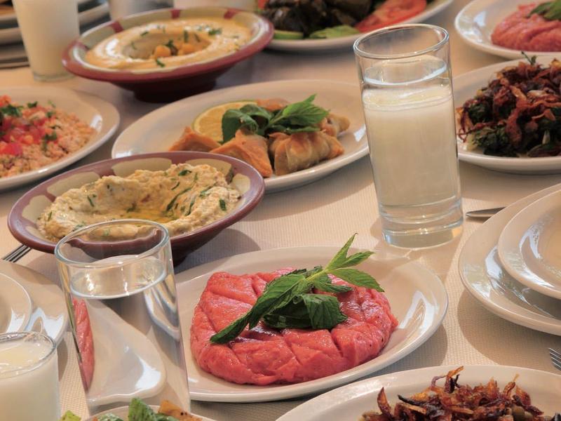 Nakryty stół z różnymi potrawami, sałatkami i napojami w szklankach.