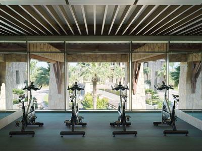 Een moderne fitnessruimte met uitzicht op een groen buitengebied en tuin.