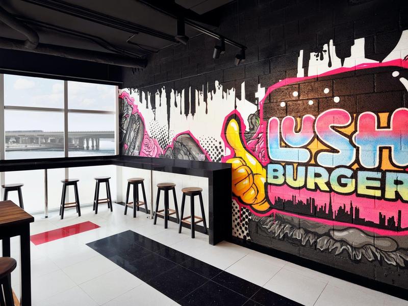 Nowoczesny kącik restauracyjny z hokerami i kolorowym graffiti na ścianie