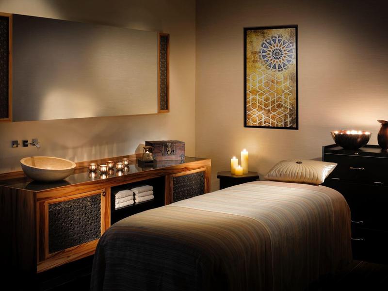 Przytulny pokój do masażu z miękkim oświetleniem i relaksującą atmosferą.