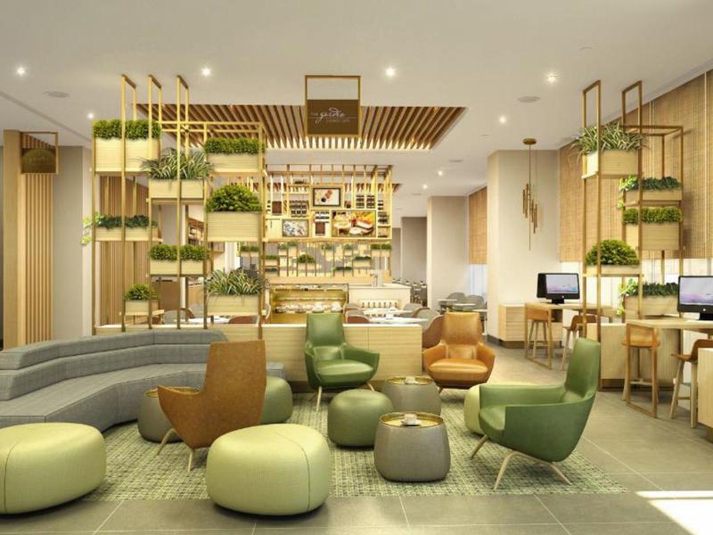 Modern lounge area with seating and plants in a warm atmosphere.