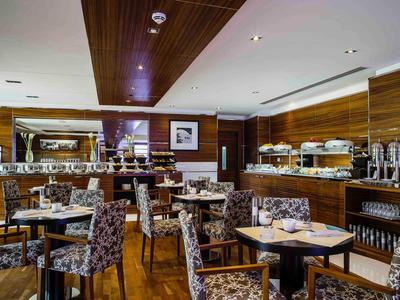 Elegantes Restaurant mit Holzwänden, modernen Stühlen und schön gedeckten Tischen.