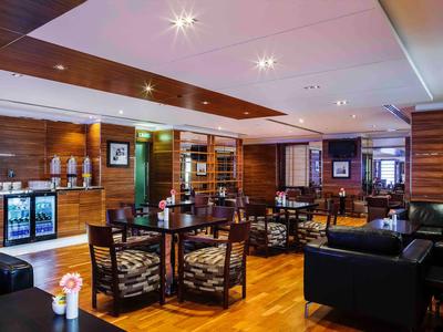 Modern eingerichteter Hotel-Loungebereich mit Sitzgruppen und Holzboden.