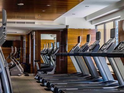 Innenansicht eines modernen Fitnessraums mit Laufbändern und hellen Fenstern im Hotel.