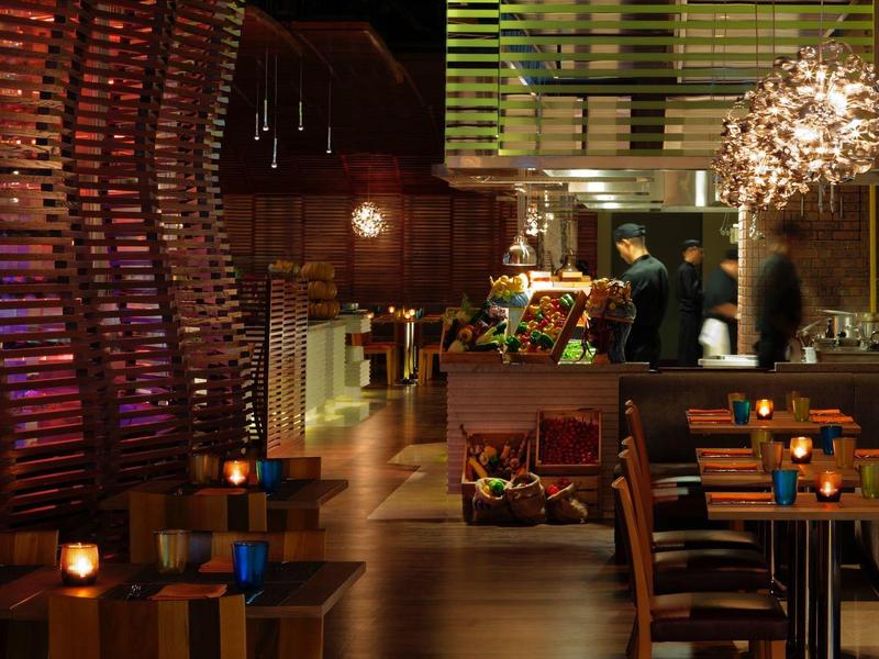 Gemütliches Restaurant mit Holzdecke, warmem Licht, Kerzen und modernem Tresen mit Bedienung.