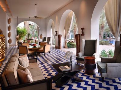 Elegantní hotelový interiér s modrobílou vzorovanou podlahou a útulnými posezeními.