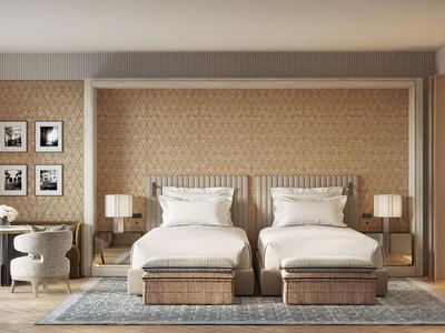 Hotelzimmer mit zwei Einzelbetten, Nachttischen, Teppichen und Schreibtisch in neutralen Tönen.