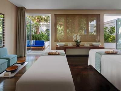 Moderní pokoj se dvěma postelemi, pohodlným posezením a výhledem do tropické zahrady.