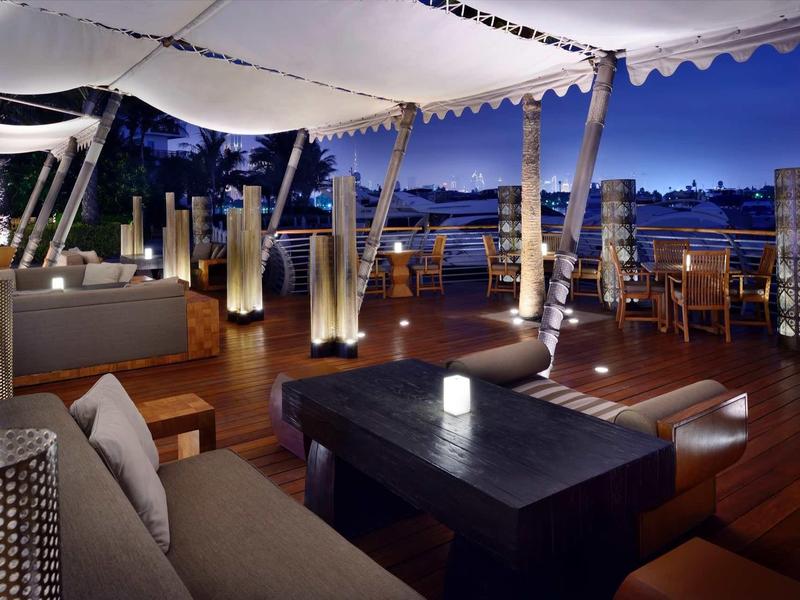 Elegantní venkovní terasa s lounge nábytkem a jemným osvětlením v noci.