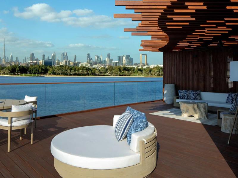 Luxusní terasa s moderním lounge nábytkem a výhledem na panorama přes vodu