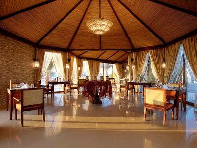 Elegantes Restaurant mit Holzdach und großen Fenstern, bestückt mit stilvollen Tischen und Stühlen.