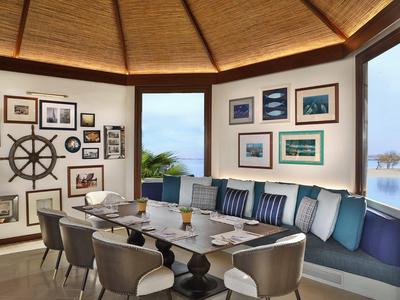 Gemütliche Hotel-Lounge mit Panoramafenstern, Sofa und maritimer Dekoration.