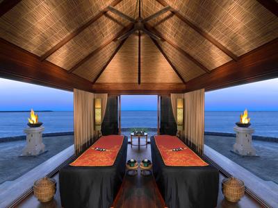 Luxuriöser Massageraum mit Blick auf das Meer und entspannender Atmosphäre bei Sonnenuntergang.