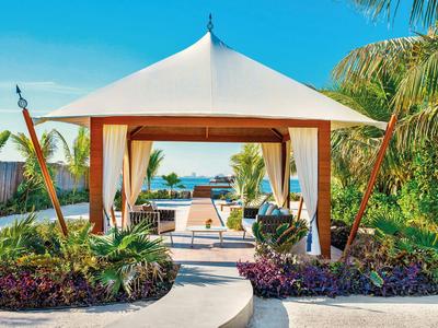Elegantes Gartenpavillon mit Blick auf das Meer in tropischem Hotelresort.