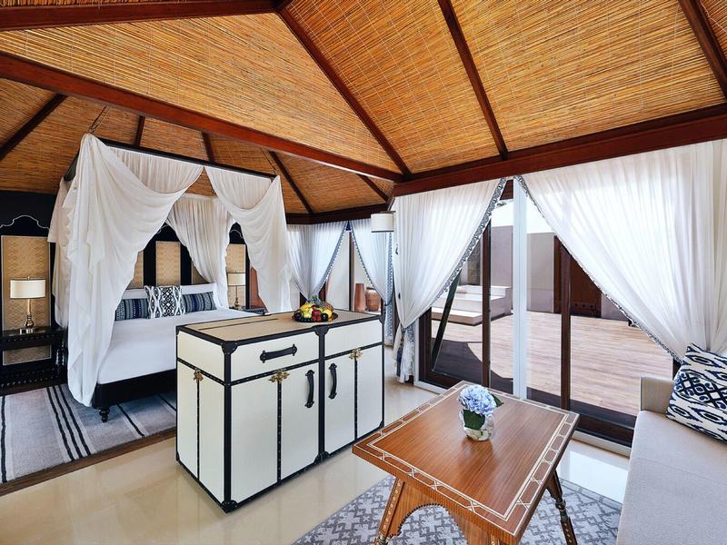 Helle, geräumige Hotel-Suite mit Holzbalkendecke und gemütlicher Lounge mit Zugang zur Terrasse.