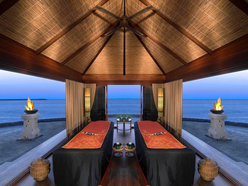 Luxuriöser Massageraum mit Blick auf das Meer und entspannender Atmosphäre bei Sonnenuntergang.