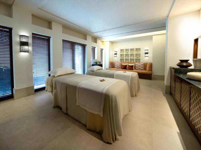 Světlá spa místnost se dvěma masážními lehátky a uklidňujícím zařízením.