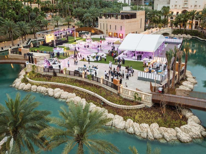 Venkovní posezení plážové restaurace s stoly, židlemi a výhledem na moře.