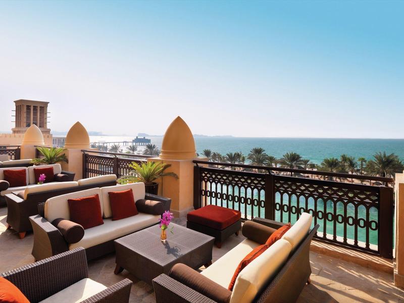 Venkovní lounge sezení s výhledem na moře za slunečného dne.