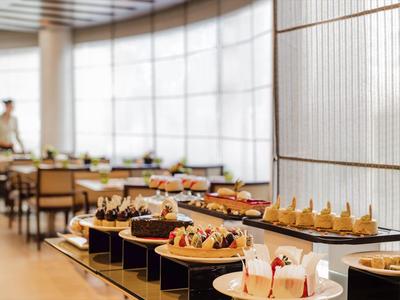 Buffet mit verschiedenen Kuchen und Desserts in einem hellen Restaurant.
