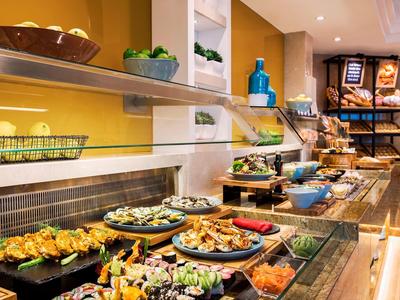 Bufet s různými pokrmy a dekorativními rostlinami v restauraci