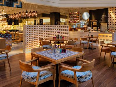 Elegantní restaurace s dřevěnou podlahou, pohodlnými židlemi a teplým osvětlením