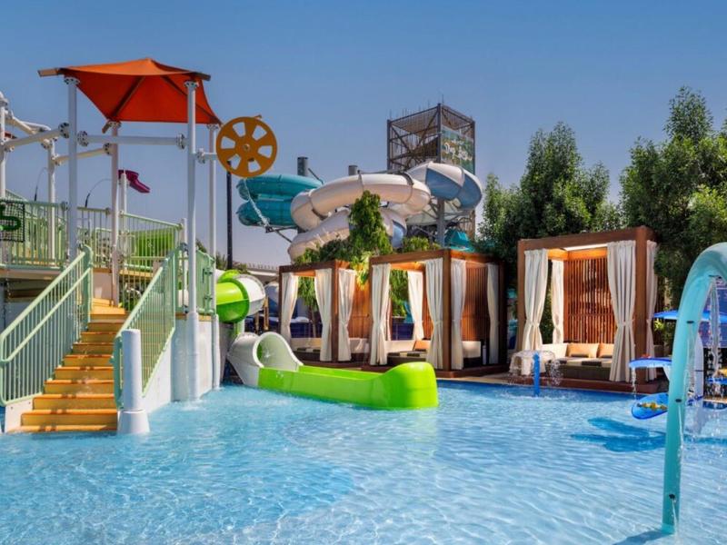 Dětský vodní park s tobogány, vodními atrakcemi a odpočinkovými zónami na slunci