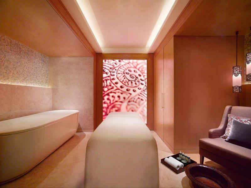 Léčební místnost s moderním designem, masážní stůl a klidné osvětlení.