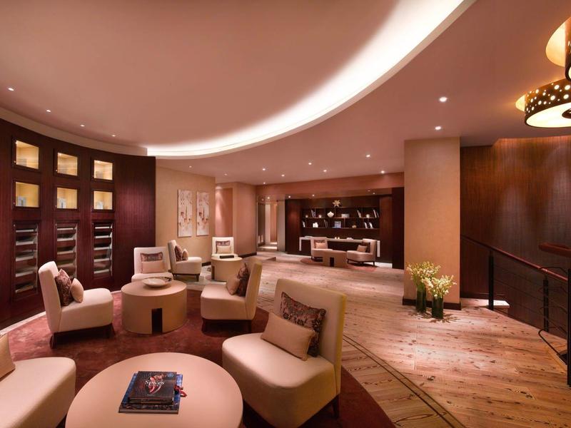 Moderní hotelový salonek s pohodlnými sedadly a teplým osvětlením.