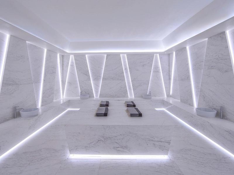 Modern bright wellness room with white marble and LED lighting.
